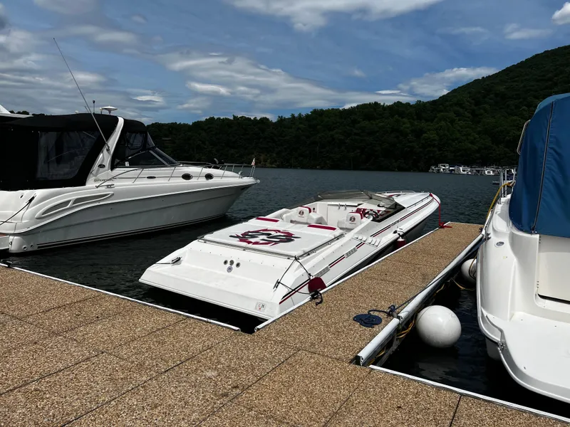 Slide: The Image of 2001 Fountain Lightning Executioner 35 speedboat docked at a marina with scenic lake and hills. - 3