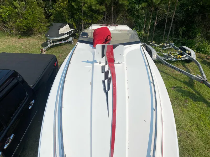 Slide: The Image of 2001 Fountain Lightning Executioner 35 boat with red and black accents, parked on grass. - 7