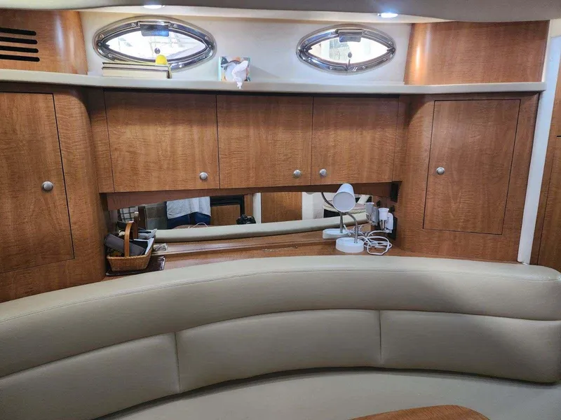 Slide: The Image of 2006 Sea Ray 340 Sundancer interior with wood cabinets and beige seating. - 11