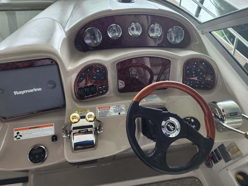 Slide: The Image of 2006 Sea Ray 340 Sundancer helm with Raymarine navigation system and wood-trimmed steering wheel. - 7