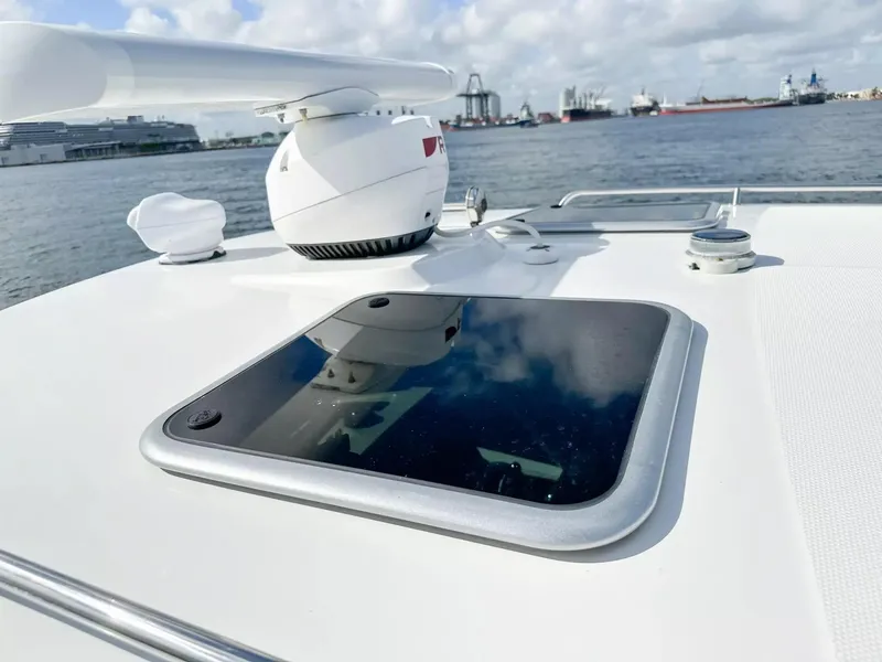 Slide: The Image of 2020 Boston Whaler 325 Conquest boat deck with radar and hatch, docked at a harbor. - 21