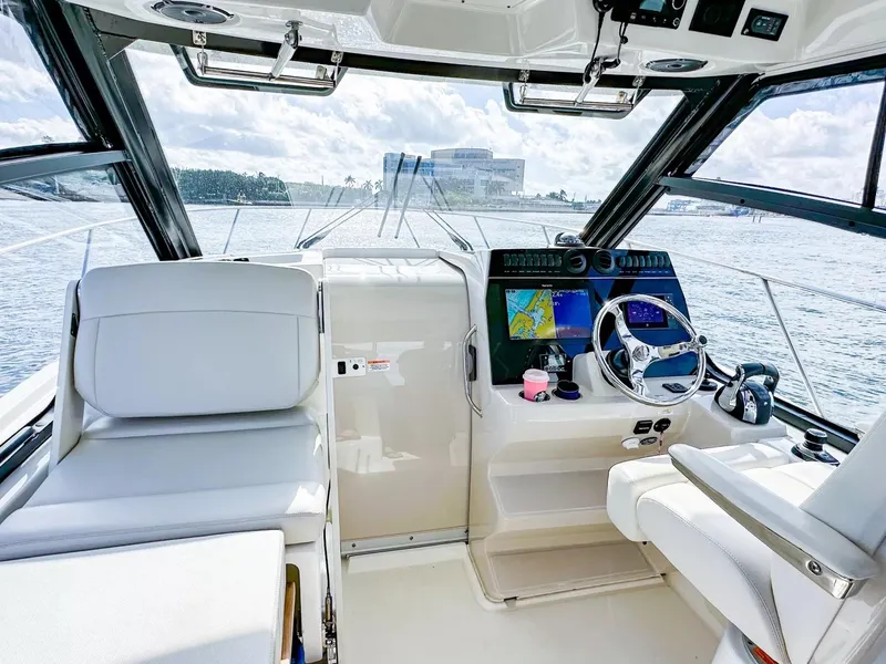 Slide: The Image of 2020 Boston Whaler 325 Conquest helm with navigation screens and steering wheel. - 29