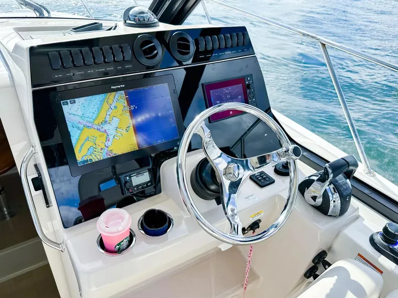 Slide: The Image of 2020 Boston Whaler 325 Conquest helm with navigation screens and steering wheel. - 31