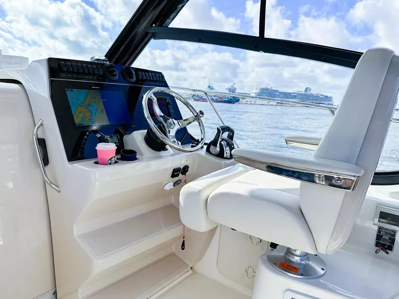 Slide: The Image of Boston Whaler 325 Conquest 2020 helm with navigation system and white captain's chair. - 32