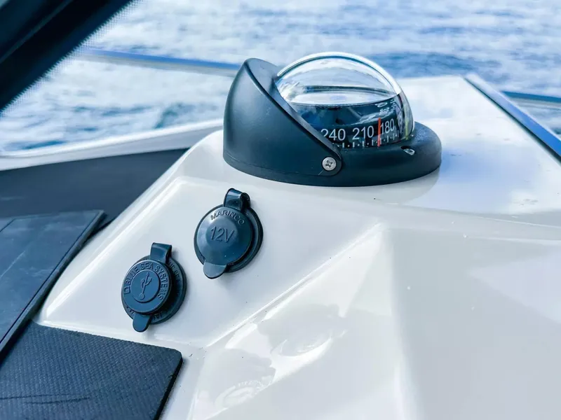 Slide: The Image of Compass and 12V outlets on a 2020 Boston Whaler 325 Conquest boat. - 39