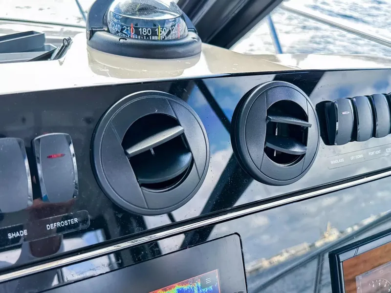 Slide: The Image of Control panel of a 2020 Boston Whaler 325 Conquest boat with air vents and compass. - 41