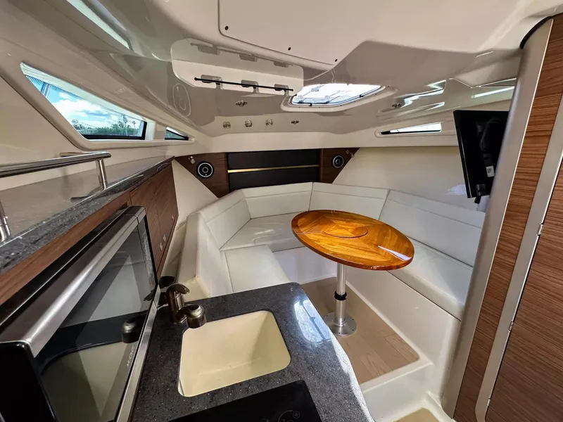 Slide: The Image of Interior of 2020 Boston Whaler 325 Conquest with modern kitchen and cozy seating area. - 49
