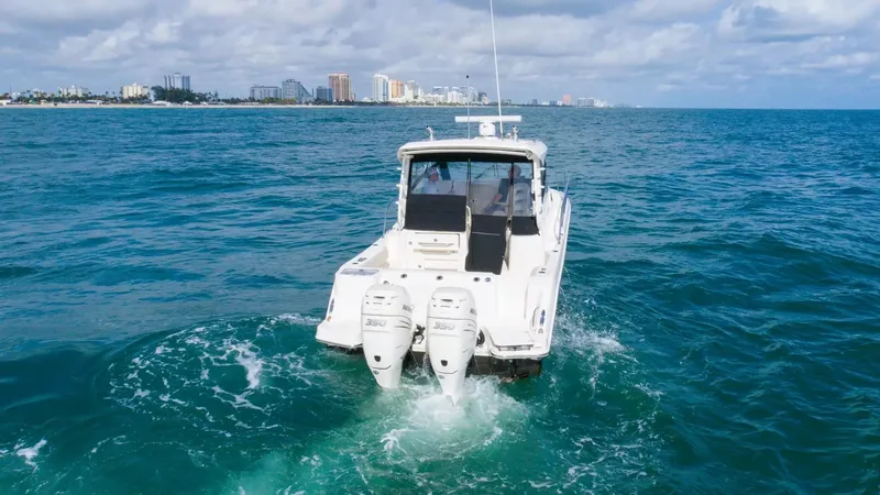 Slide: The Image of 2020 Boston Whaler 325 Conquest cruising on the ocean with city skyline in the background. - 8