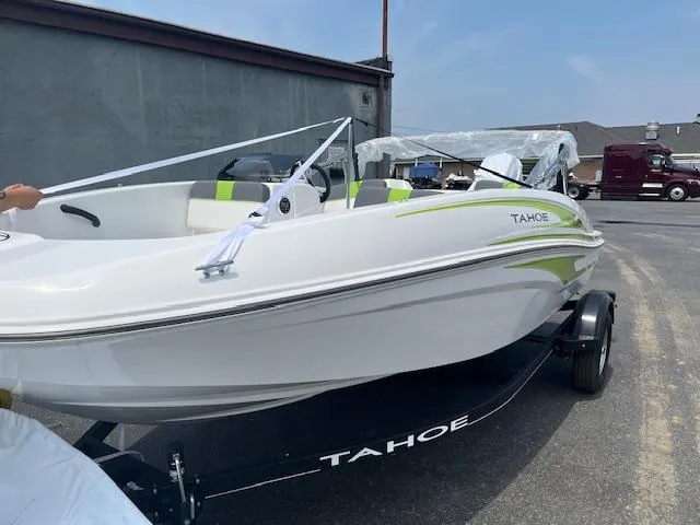 Slide: The Image of 2024 Tahoe T16 boat on trailer, white with green accents, parked outdoors. - 1
