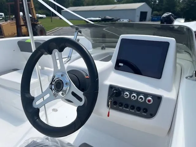 Slide: The Image of 2024 Tahoe T16 boat dashboard with steering wheel and control panel. - 2