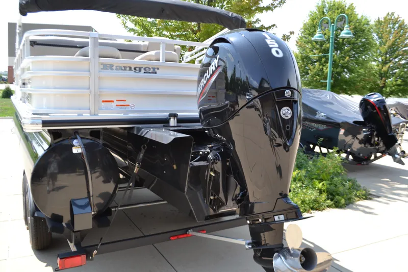 Slide: The Image of 2024 Ranger Reata 223FC boat with Mercury outboard motor, parked outdoors. - 2