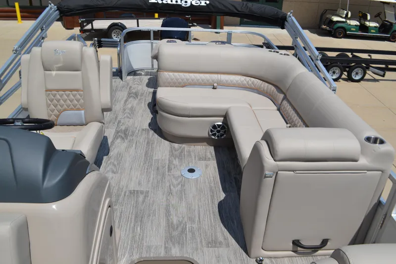 Slide: The Image of 2024 Ranger Reata 223FC boat interior with beige seating and wood-style flooring. - 3