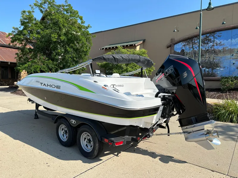 Slide: The Image of 2024 Tahoe 1950 boat on trailer, parked outdoors, featuring sleek design and powerful engine. - 2