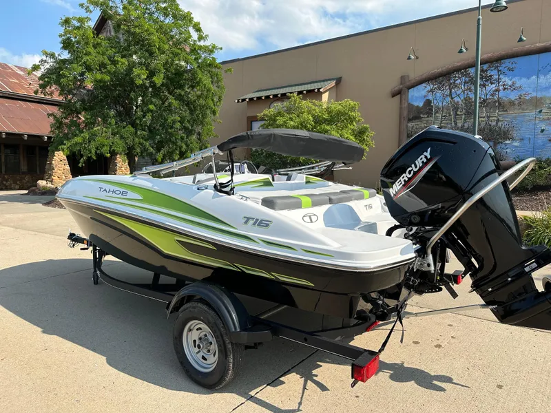 Slide: The Image of 2024 Tahoe T16 boat with Mercury engine on trailer, parked outdoors. - 2