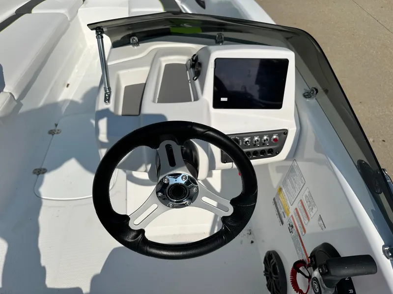 Slide: The Image of 2024 Tahoe T16 boat dashboard with steering wheel and control panel. - 4