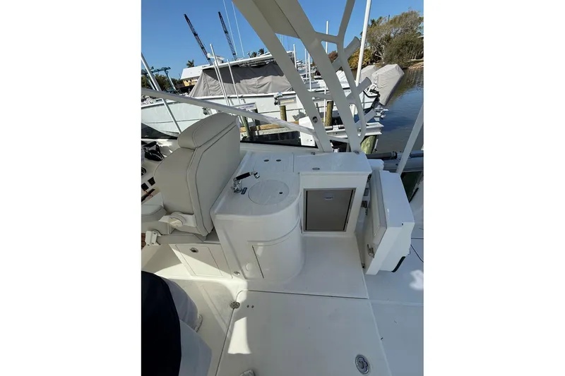 Slide: The Image of 2026 World Cat 325 DC boat interior with seating and storage, docked at marina. - 11