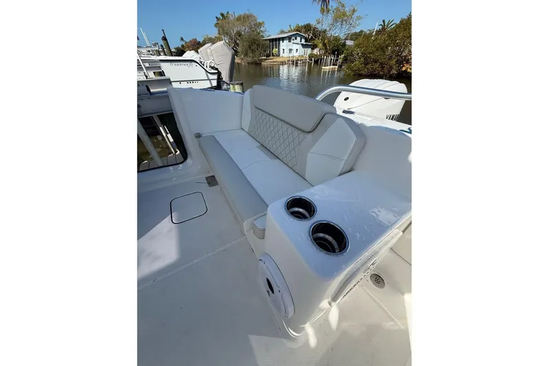 Slide: The Image of 2026 World Cat 325 DC boat interior with cushioned seating and cup holders. - 16
