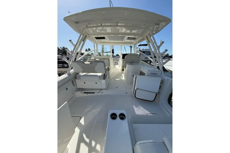Slide: The Image of 2026 World Cat 325 DC boat interior with seating and storage, under clear blue sky. - 22
