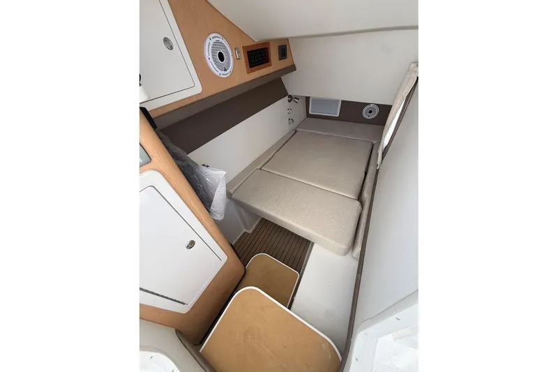 Slide: The Image of Interior cabin of 2026 World Cat 325 DC boat, featuring cozy sleeping area and storage. - 23