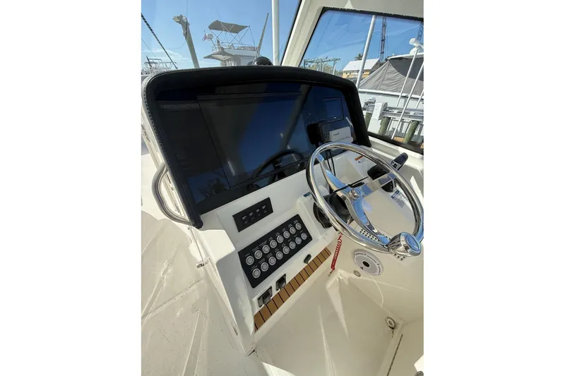 Slide: The Image of Helm of 2026 World Cat 325 DC boat with steering wheel and control panel. - 5