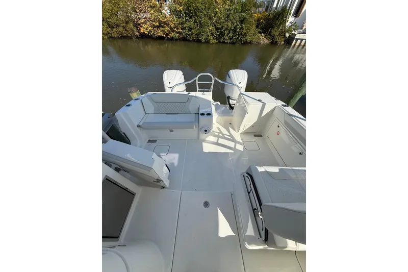 Slide: The Image of 2026 World Cat 325 DC boat interior with spacious seating and sleek design on calm water. - 9