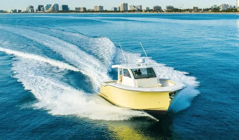 Slide: The Image of 2019 Altima Xcape Sport 38 SFE boat cruising on open water near city skyline. - 1