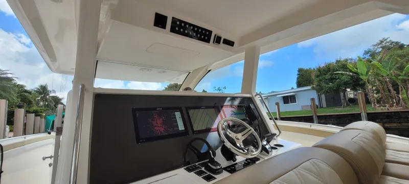 Slide: The Image of 2019 Altima Xcape Sport 38 SFE boat interior with modern dashboard and steering wheel. - 13