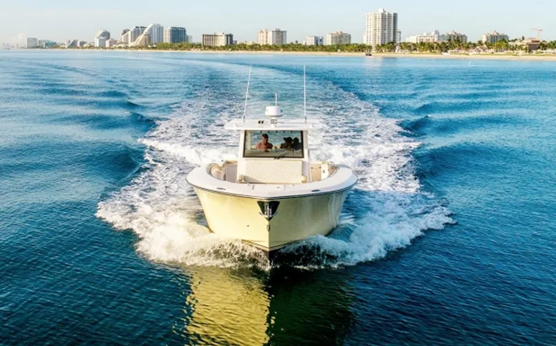 Slide: The Image of 2019 Altima Xcape Sport 38 SFE cruising on blue ocean near city skyline. - 2