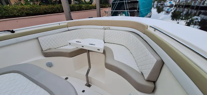 Slide: The Image of 2019 Altima Xcape Sport 38 SFE boat interior with cushioned seating and small table. - 9