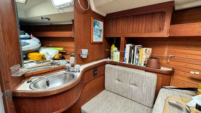 Slide: The Image of Cozy interior of 1990 Sabre 38 sailboat with sink, seating, and books. - 11
