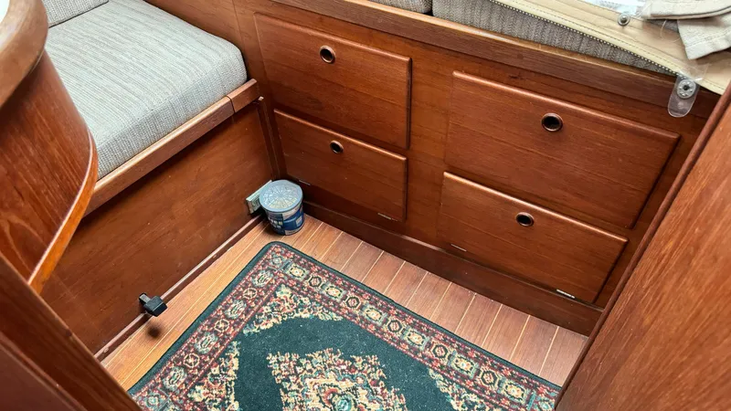 Slide: The Image of Interior of a 1990 Sabre 38 sailboat with wooden cabinetry and a decorative rug. - 12