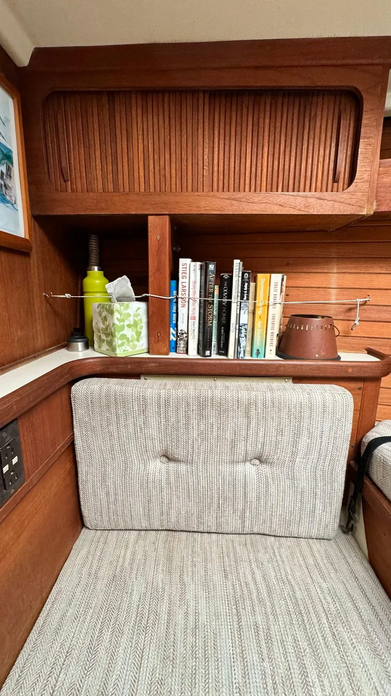Slide: The Image of Interior of 1990 Sabre 38 sailboat with wooden shelves and books. - 13