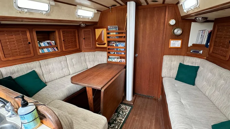 Slide: The Image of Cozy interior of a 1990 Sabre 38 sailboat with cushioned seating and wooden accents. - 2