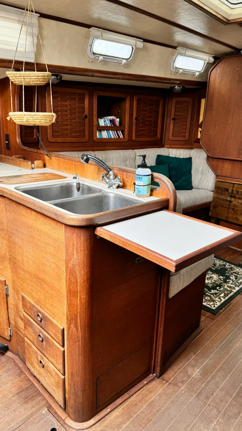 Slide: The Image of 1990 Sabre 38 yacht interior with wooden cabinetry and kitchen sink. - 20
