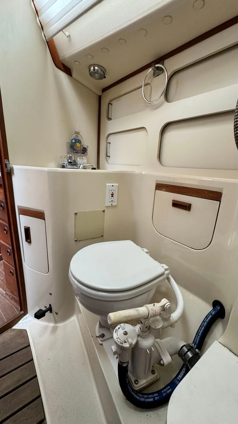 Slide: The Image of 1990 Sabre 38 yacht bathroom with compact marine toilet and storage. - 25