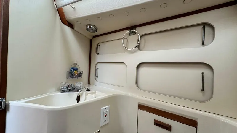 Slide: The Image of 1990 Sabre 38 yacht bathroom with sink, storage compartments, and modern fixtures. - 26