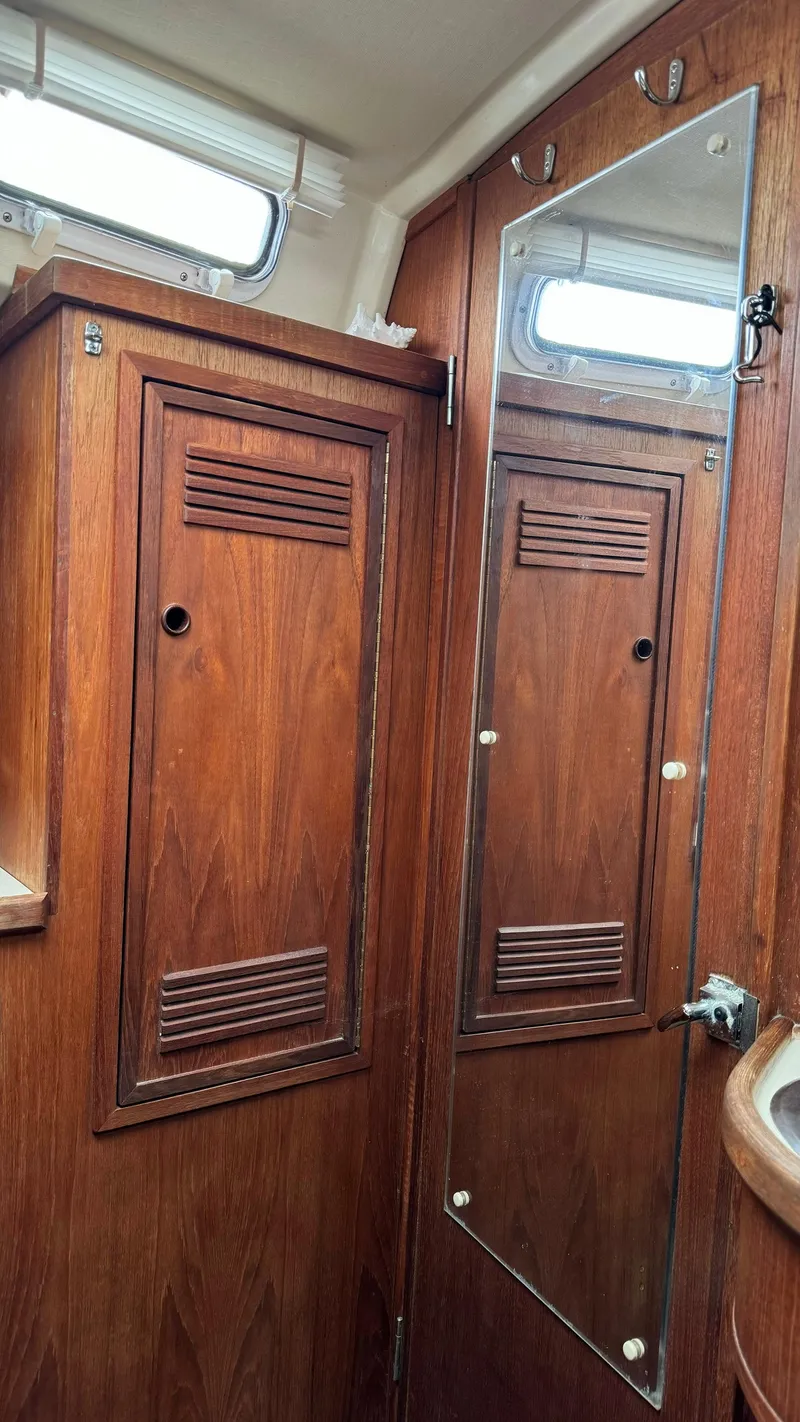 Slide: The Image of Interior of a 1990 Sabre 38 sailboat with wooden cabinets and a mirror. - 3