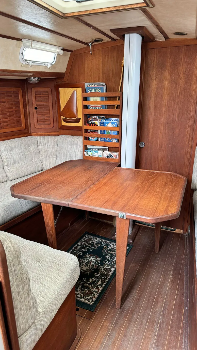Slide: The Image of 1990 Sabre 38 sailboat interior with wooden dining table and cushioned seating. - 4
