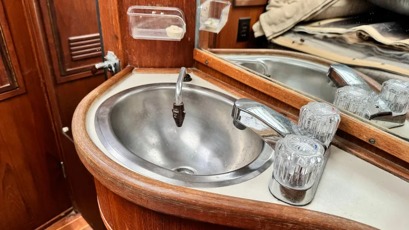 Slide: The Image of 1990 Sabre 38 yacht bathroom sink with wooden cabinetry and chrome fixtures. - 5