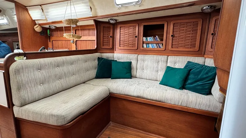 Slide: The Image of Cozy interior of 1990 Sabre 38 sailboat with cushioned seating and wooden cabinetry. - 8