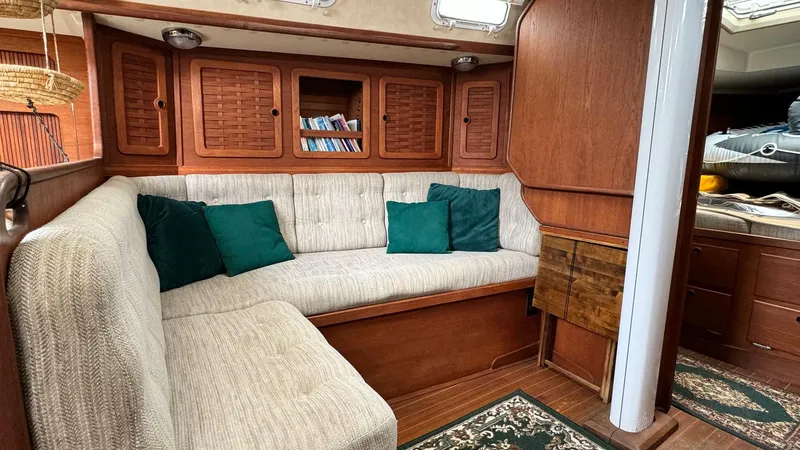 Slide: The Image of Cozy interior of 1990 Sabre 38 sailboat with cushioned seating and wooden cabinetry. - 9