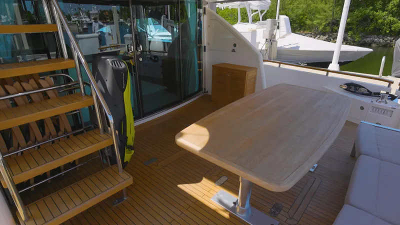 Slide: The Image of 2014 Fairline Squadron 78 Custom yacht deck with wooden table and stairs. - 18