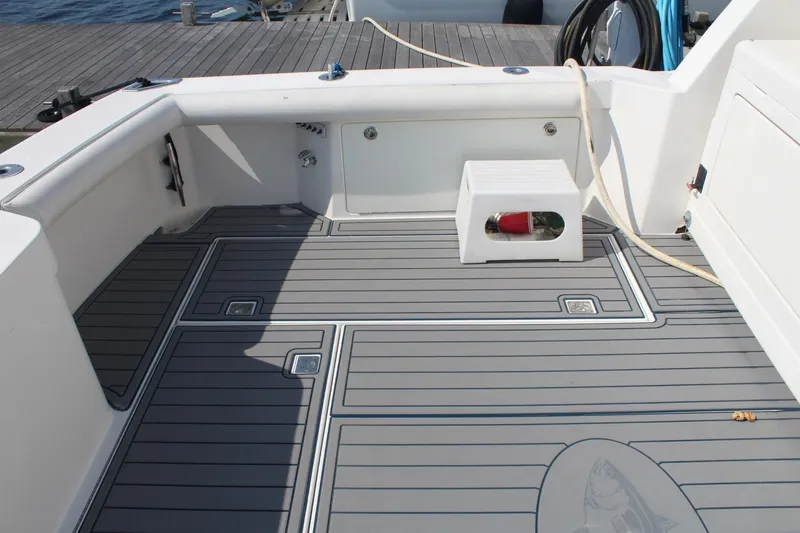 Slide: The Image of 2013 Cabo 40 Hardtop Express boat deck with gray flooring and white seating. - 12