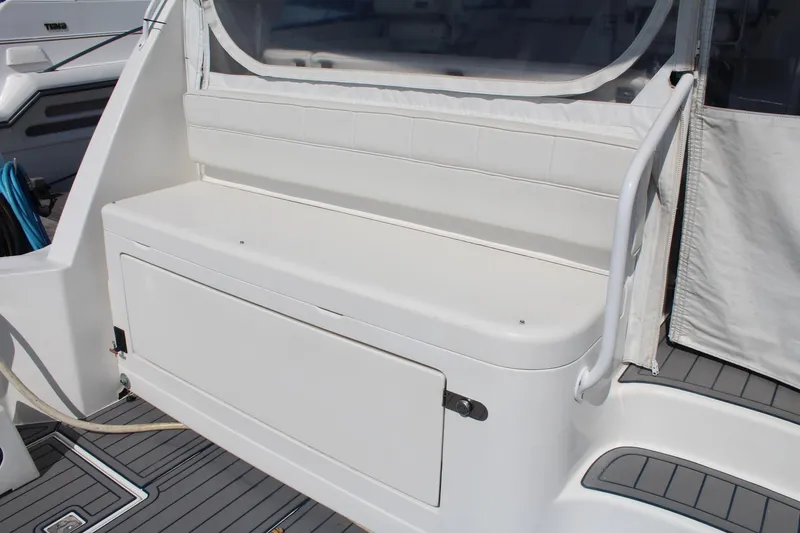 Slide: The Image of 2013 Cabo 40 Hardtop Express boat seating area with storage compartment. - 14