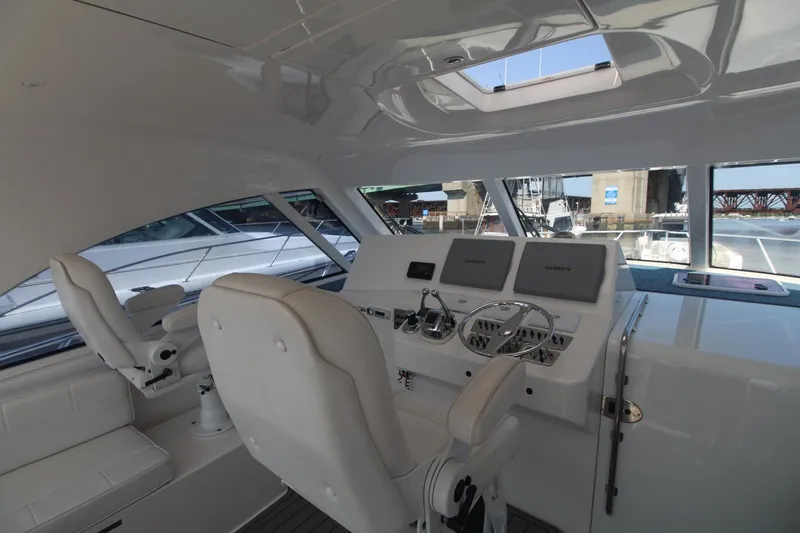 Slide: The Image of Interior helm of 2013 Cabo 40 Hardtop Express yacht with modern controls and seating. - 17
