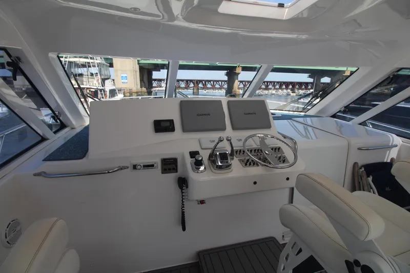 Slide: The Image of Helm of 2013 Cabo 40 Hardtop Express yacht with modern controls and navigation equipment. - 20