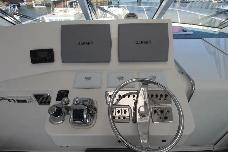 Slide: The Image of Helm of 2013 Cabo 40 Hardtop Express with Garmin navigation displays and controls. - 26