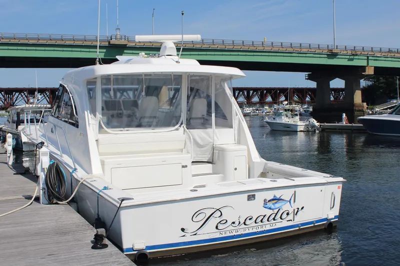 Slide: The Image of 2013 Cabo 40 Hardtop Express yacht docked near a bridge. - 3