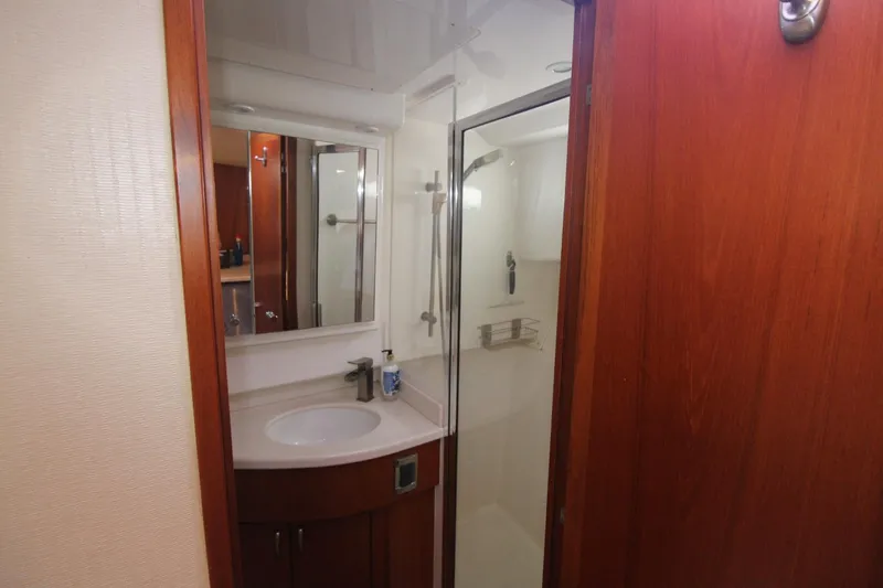 Slide: The Image of 2013 Cabo 40 Hardtop Express bathroom with shower, sink, and wooden cabinetry. - 34