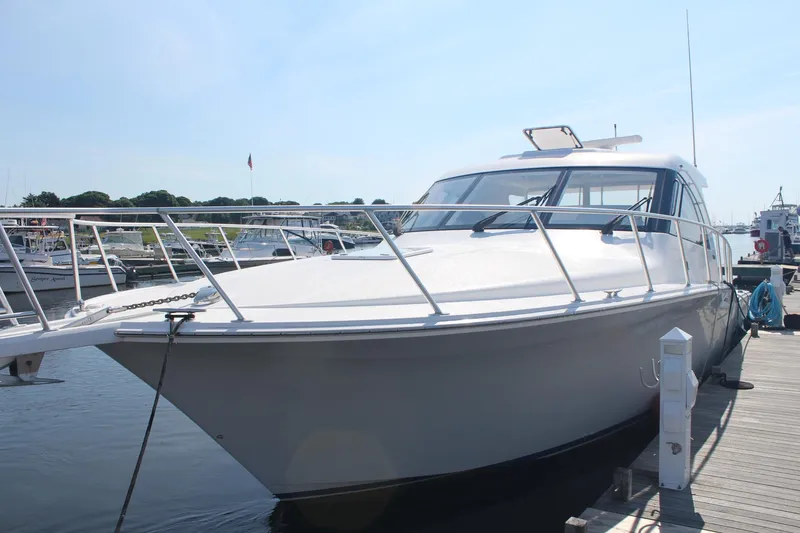 Slide: The Image of 2013 Cabo 40 Hardtop Express yacht docked at marina under clear sky. - 4